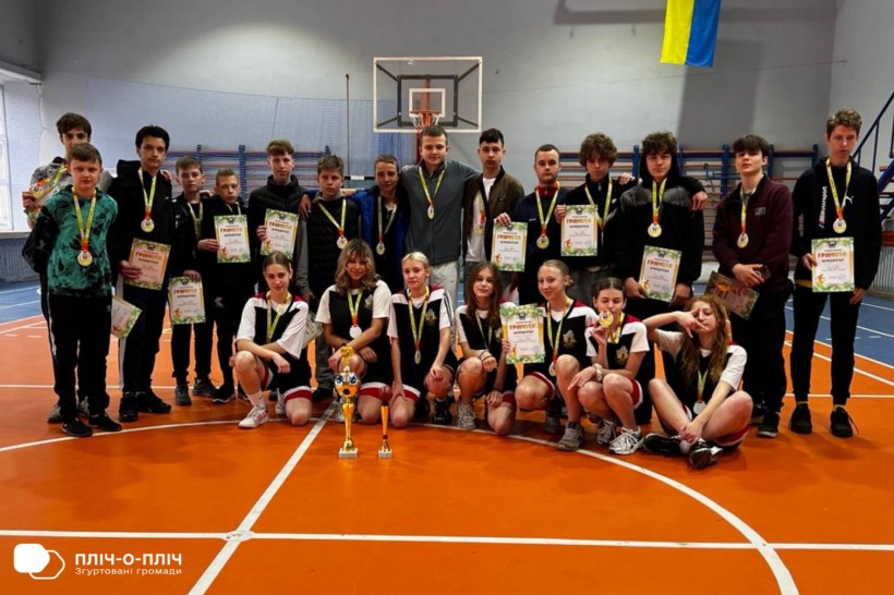 Команда спортсменів з дипломами та кубками позує у спортивному залі в Перечині