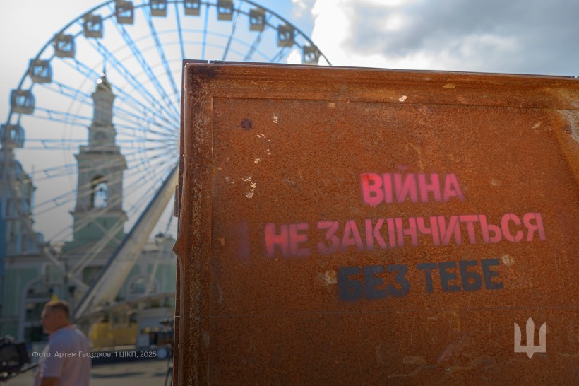 Металеві ворота, на яких надпис "Війна не закінчиться без тебе ".
Фотовиставка на Контрактовій площі, місто Київ.