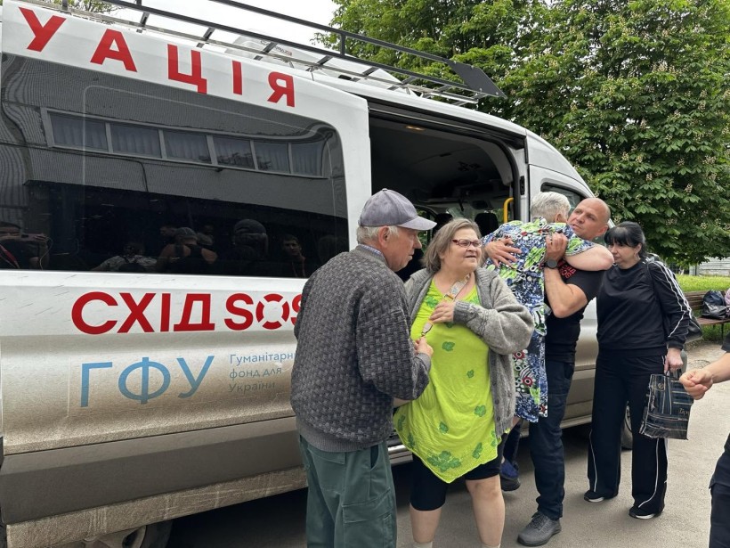 Жінки та чоловіки сідають до евакуаційного транспорту