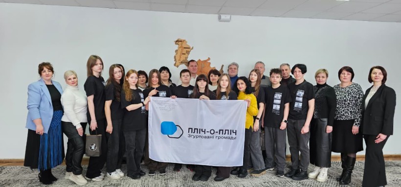 Спільне фото дітей з Селідівської громади з представниками Бориславської міської ради, попереду тримають прапор  «Пліч-о-пліч: згуртовані громади».