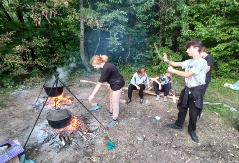 Побут табору. Учасники самостійно організовують приготування їжі на відкритому вогні, що сприяє розвитку навичок самозабезпечення в польових умовах.