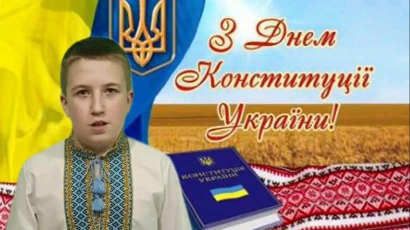 Учасник конкурсу декламує вірш до Дня Конституції України. На фоні - державна символіка та вітальне гасло.