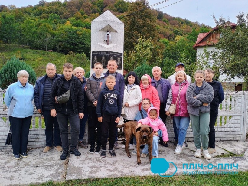 Спільне фото,біля рідкісной скульптури бджоли в мармурі. На передньому плані маленька дівчинка у рожевій курточці та велика собака.