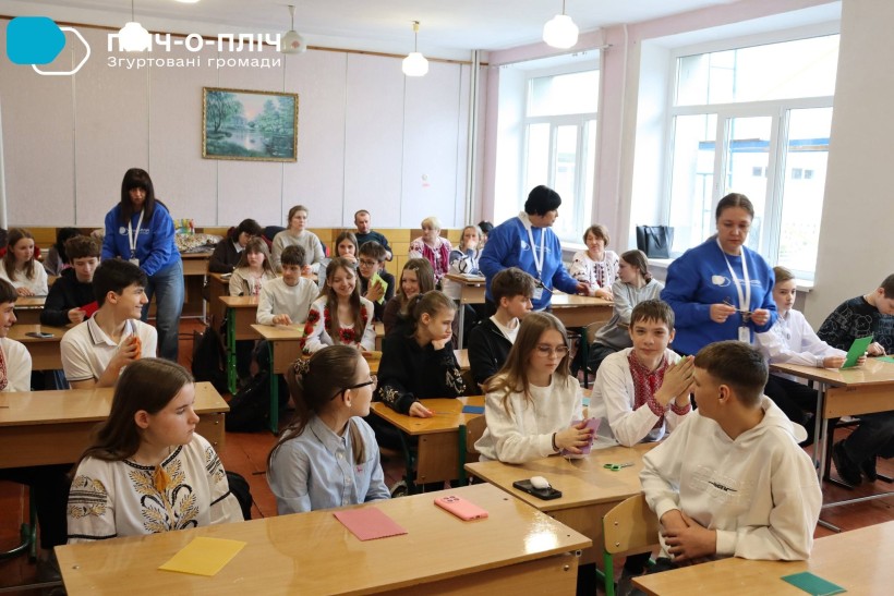 Майстер-клас з виготовлення та оздоблення Великодніх свічок з вощини  у Ружині . Учні сидять за партами у класі.