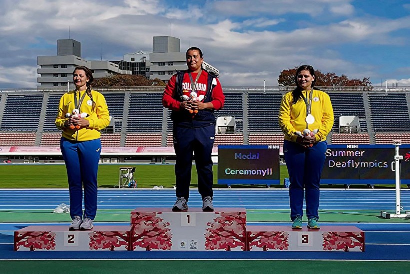 Українські спортсменки тримають медалі на постаменті