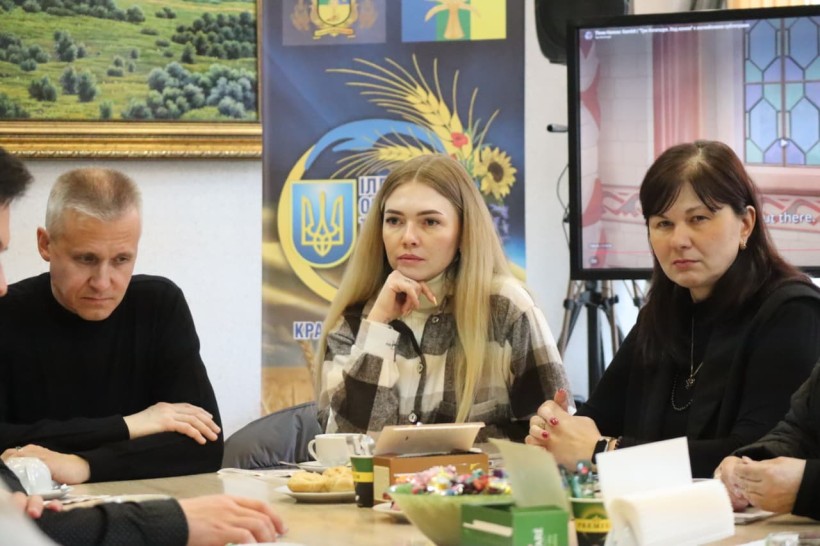 Учасники зустрічі сидять за столом.