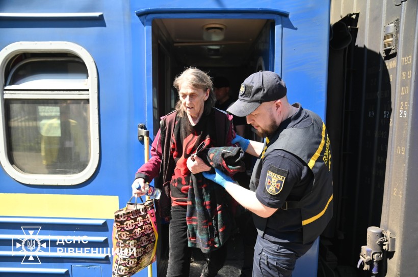 Рятувальники зустрічають людей з евакуаційного потяга, який придув до Рівненської області