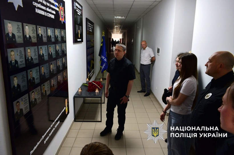 Поліцейські разом з родинами загиблих переглядають дошку пошани