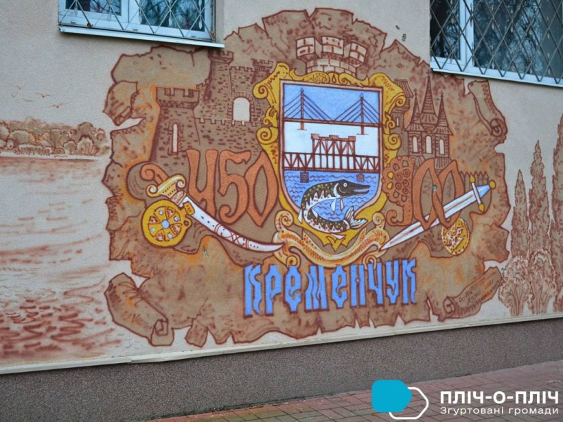 На стіні намальований герб міста Кременчук.