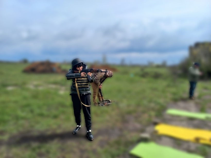 Учасниця навчання відпрацьовує практичні навички з вогнепальною зброєю