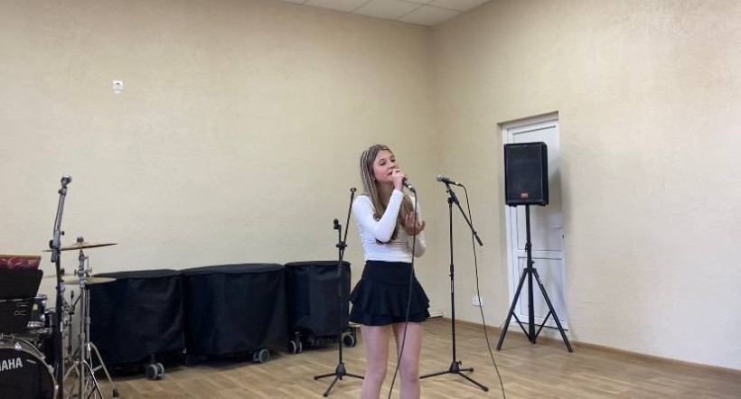 Учасниця конкурсу виконує пісню з мікрофоном