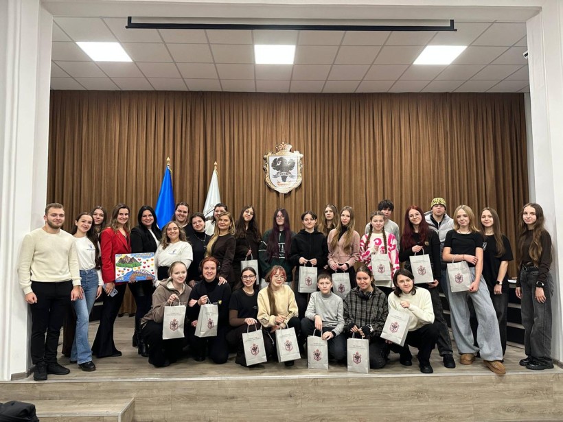 Спільне фото.
Хлопці та дівчата тримають у руках паперові пакети та посміхаються