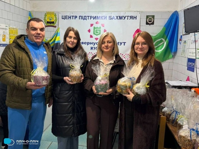 Переселенці з Бахмута тримають пасочки, передані від громад-партнерів