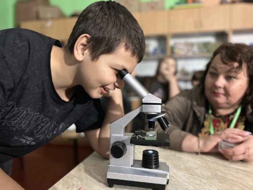 Заняття з мікроскопом. Вихованець Донецького обласного еколого-натуралістичного центру проводить дослід.