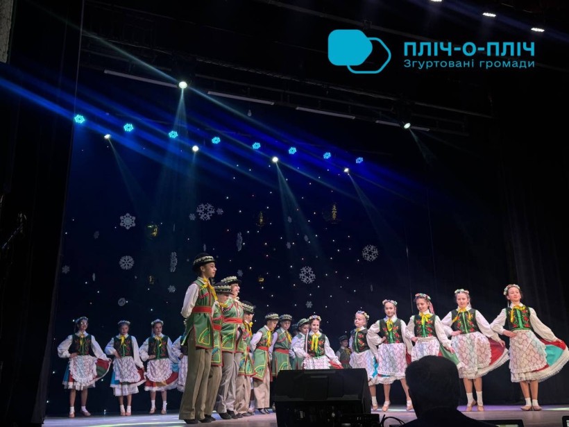 Артисти народного колективу на сцені у народних костюмах.