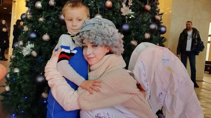 Дитина обіймає акторку в костюмі ангела