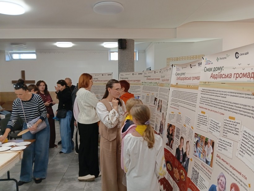 Відвідувачі заходу розглядають інформаційні стенди виставки.