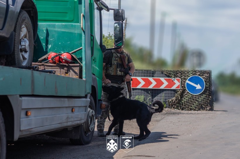 Кінологічна пара 18-ї Слов'янської бригади проводить огляд машини на блокпосту