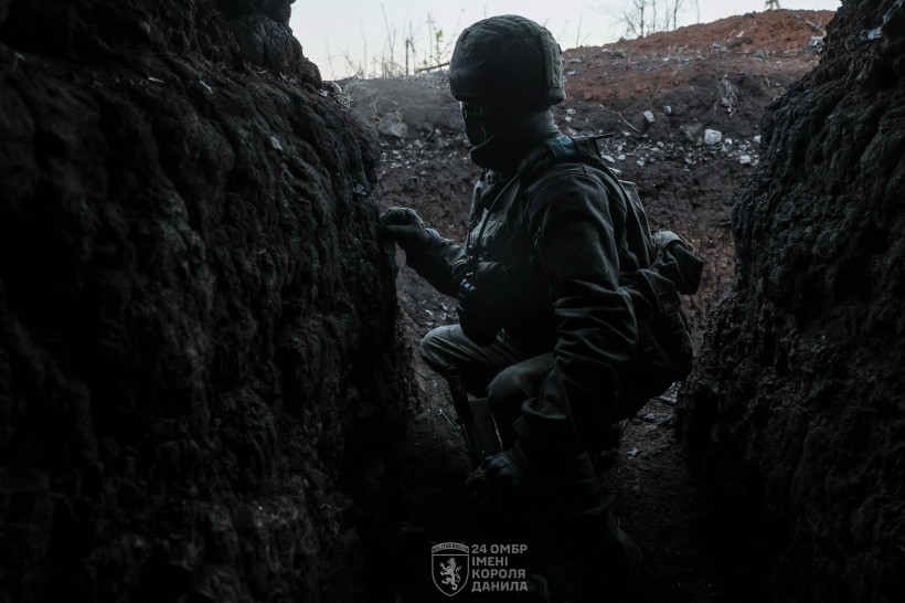 Військовий в окопі. У шоломі та броніжелеті.