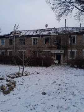 Будинок з пошкодженими вікнами після обстрілу