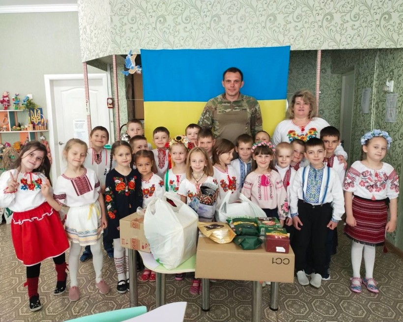 Діти-ВПО у вишиванках разом із військовим і вихователями на патріотичному заході, присвяченому підтримці захисників.