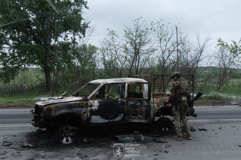 Згоріла військова автівка, поруч стоїть військовий