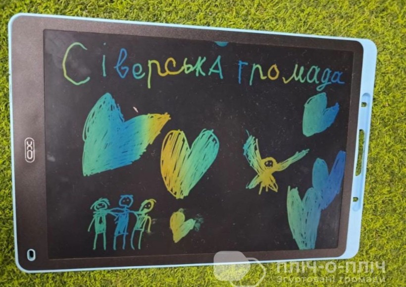 Графічний планшет на траві з написом "Сіверська громада"