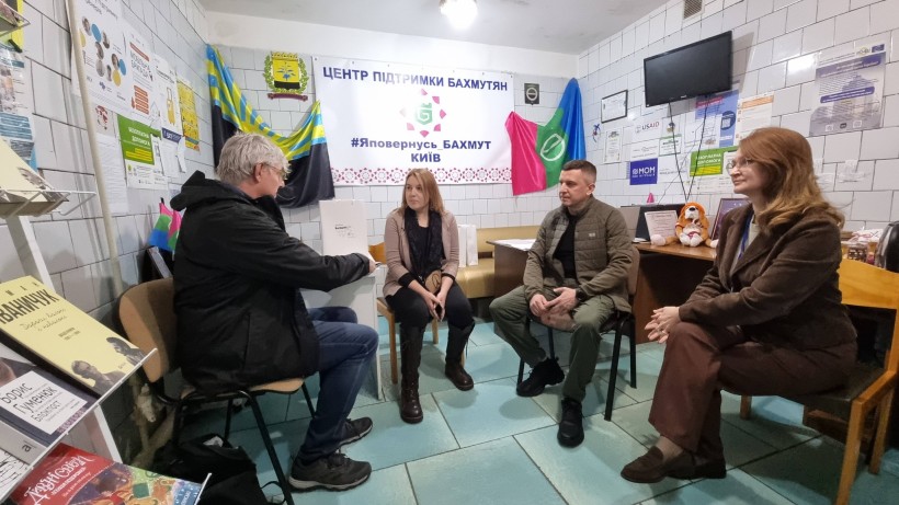 Спілкування учасників зустрічі, позаду прапори Донеччини та Бахмутської громади.