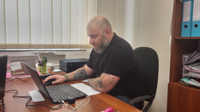 У світлому офісі за робочим столом сидить Артур Насібян - начальник управління з питань ветеранської політики Донецької області. Він приймає участь в онлайн зустрічі з ветеранами та членами родин загиблих (померлих) Захисників і Захисниць України Дружківської міської територіальної громади.