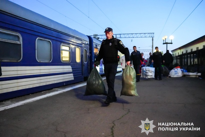 Поліцейський несе речі на пероні