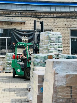 Погрузчик розвантажує палети гуманітарної допомоги.