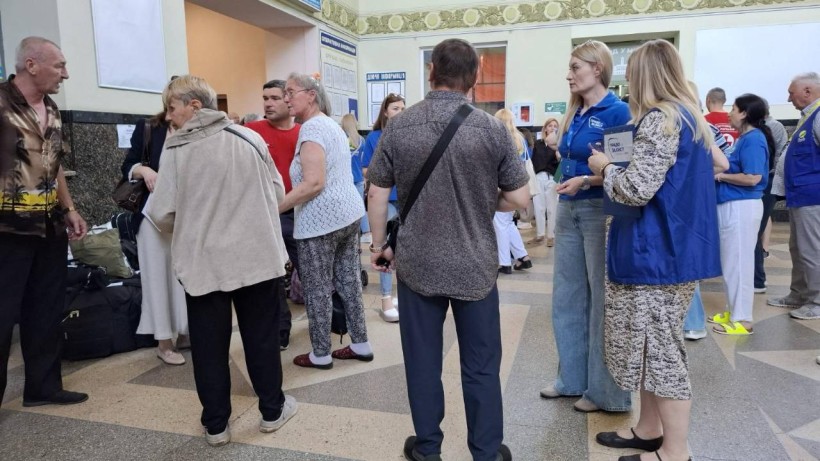 Евакуйовані мешканці Донеччини разом з волонтерами чекають в залі очікування на вокзалі.
