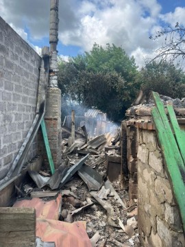 Зруйнована ворожим обстрілом прибудинкова будівля.