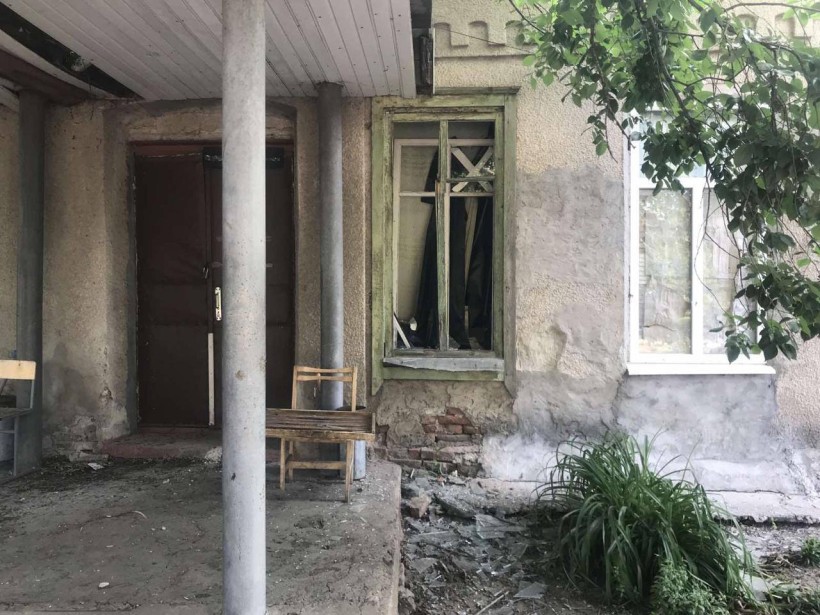 Будинок з вибитим через ворожий обстріл вікном.