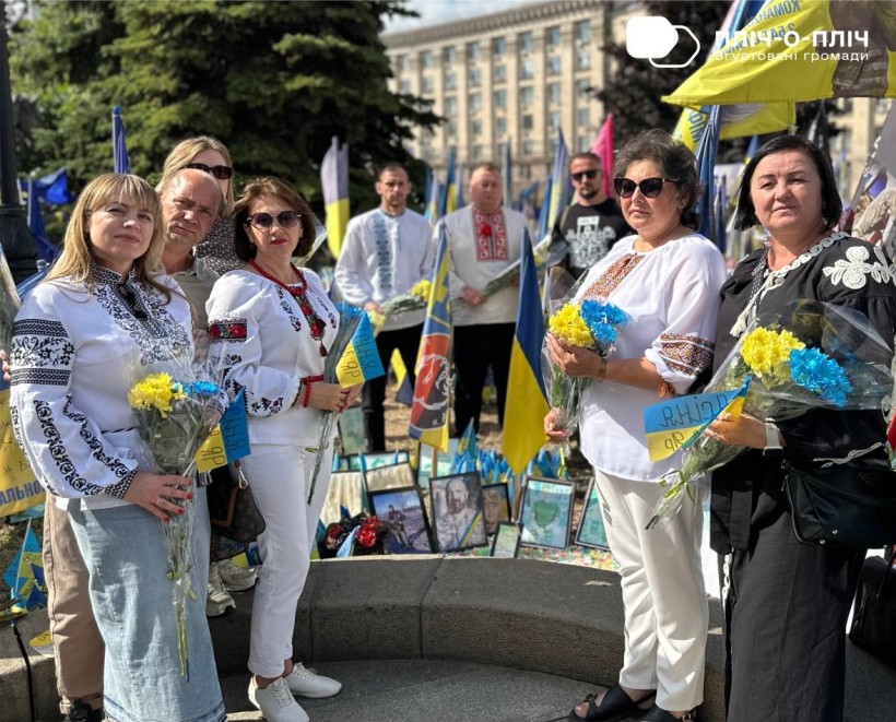 Представники двох громад встановлюють прапорці
