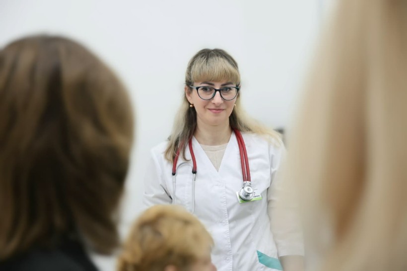 Лікар у білому халаті спілкується з пацієнтами.