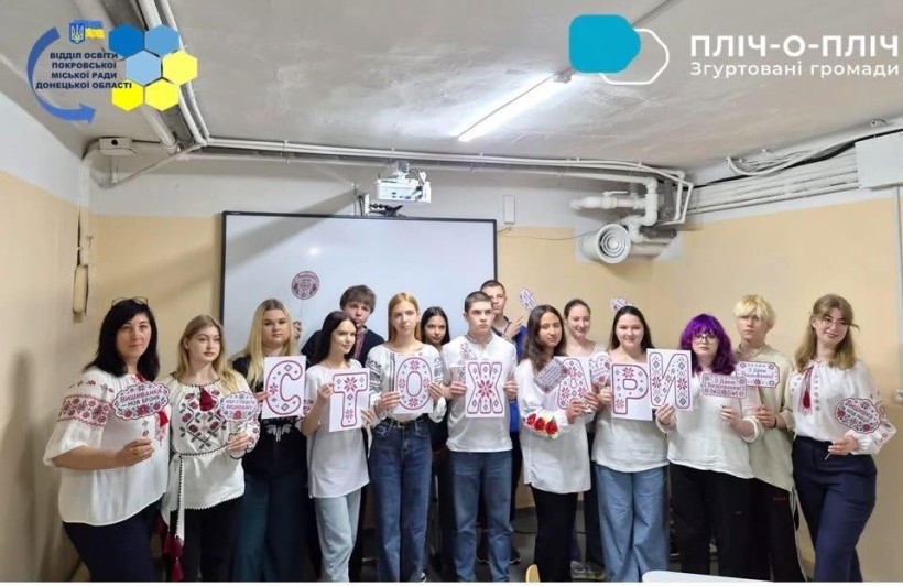 Школярі у вишиванках тримають літери, розмальовані під вишиванку