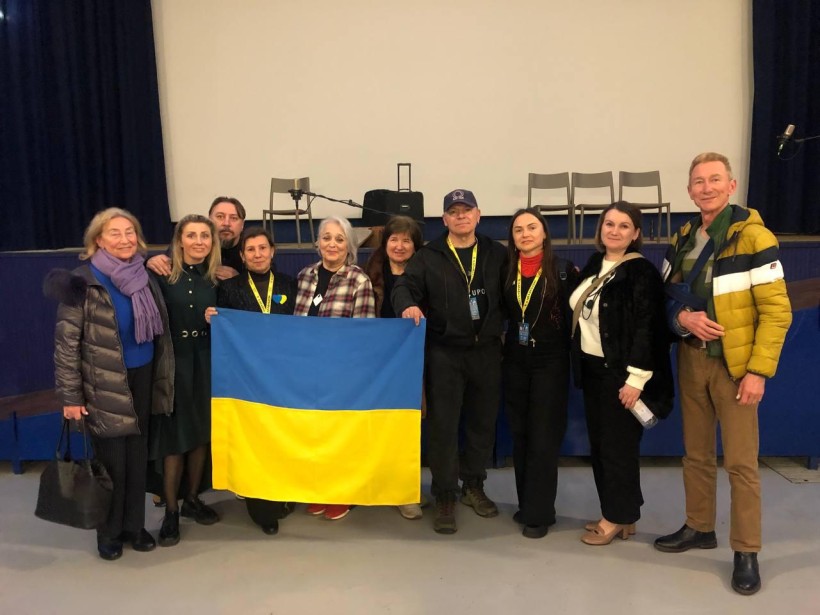 Спільне фото акторів на сцені по переду тримають прапор України.