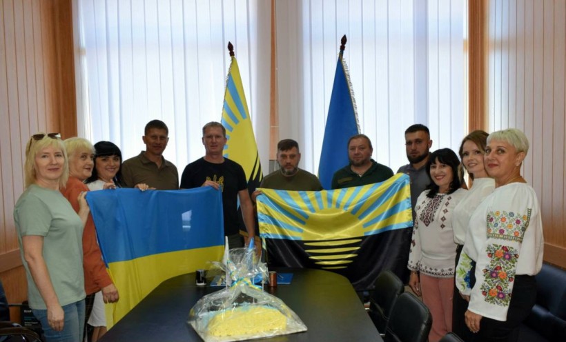 Дві громади, спільне фото. Попереду тримають прапори України та Донеччини. На столі лежить пиріг Незалежності від Очеретинської громади.