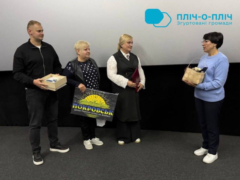 Делегація з Покровська передає подарунки, тримає картину з логотипом Донеччини.