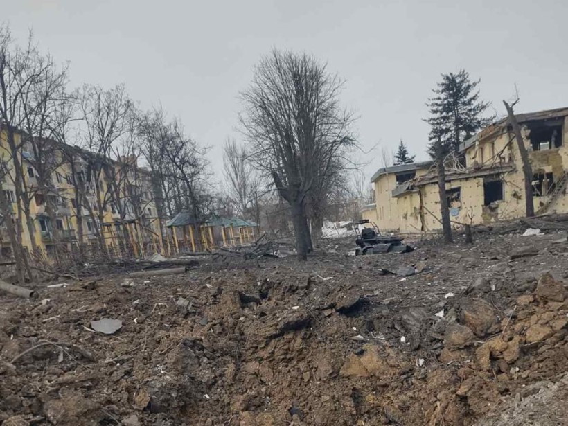 Вирва після ворожої авіабомби біля пошкоджених будинків