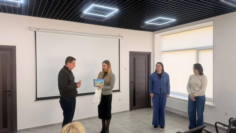 Представниця громади дарує гру "Код Донеччини".