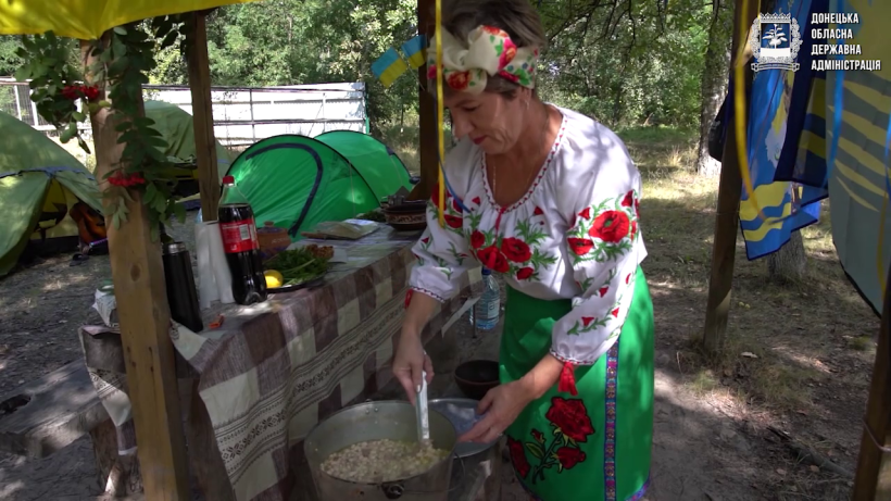 Жінка у національному вбранні готує на фестивалі куліш