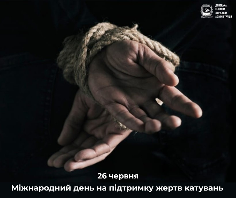 Руки, зв'язані мотузкою, на темному тлі, що передає відчуття безпорадності. Текст нижче посилається на Міжнародний день підтримки жертв тортур.