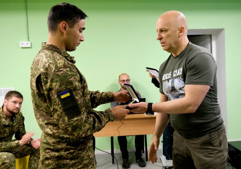 Боєць 3 бригади НГУ "Спартан" отримує нагороду з рук Вадима Філашкіна.