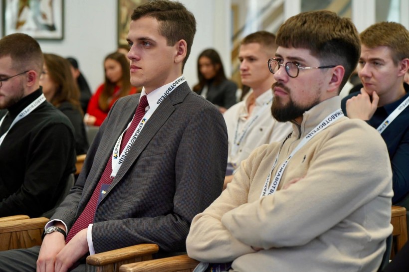 Двоє чоловіків крупним планом, учасники заходу. Уважно слухають.