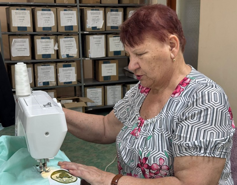 Жінка шиє адаптивний одяг для поранених військових