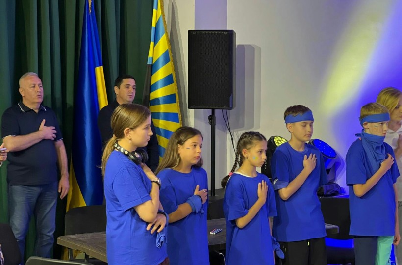 Юні учасники фестивалю тримають руку на серці під час виконання Гімну