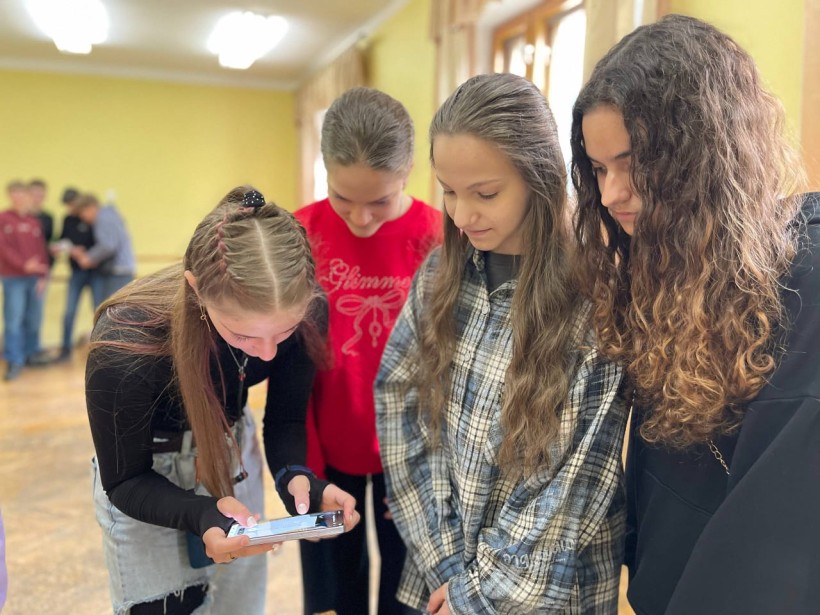 Діти уважно дивляться на екран телефона