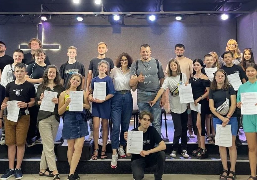 Євген Моїсеєв – засновник громадської організації «Гоу френдс» разом зі своїми учнями, які тримають сертифікати про закінчення освітньої програми соціального проєкту «GoFriendsITAcademy»